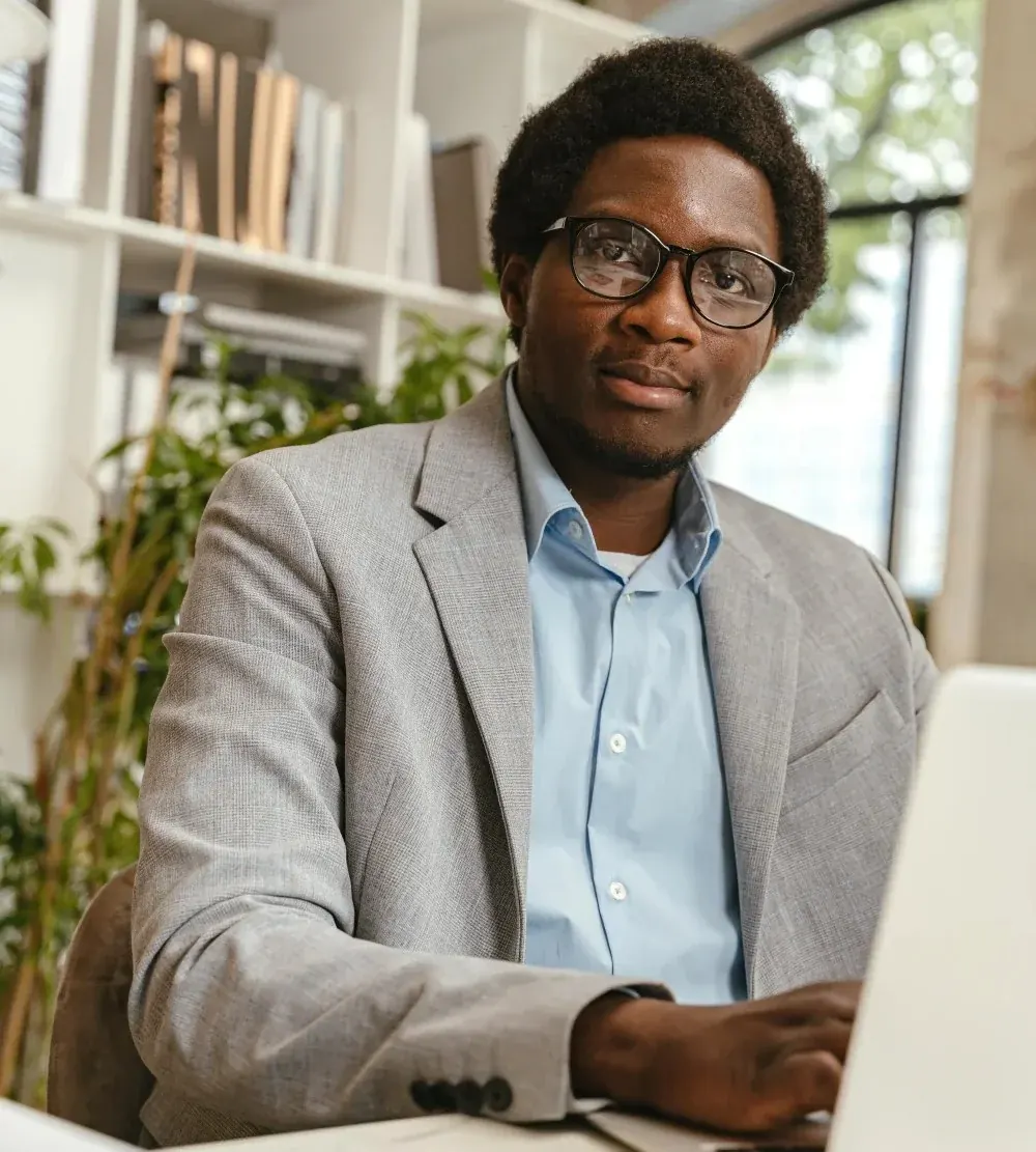 Man in a blazer working at a laptop